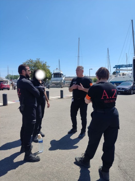 Quatre agents en discussion, dont un au visage flouté